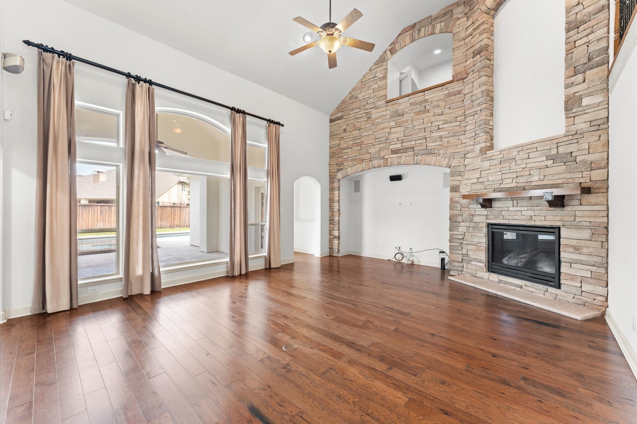 3 North Beech Springs Circle Spring, TX 77389 - Photo 9 of 43 an empty room with wooden floor a fireplace and windows