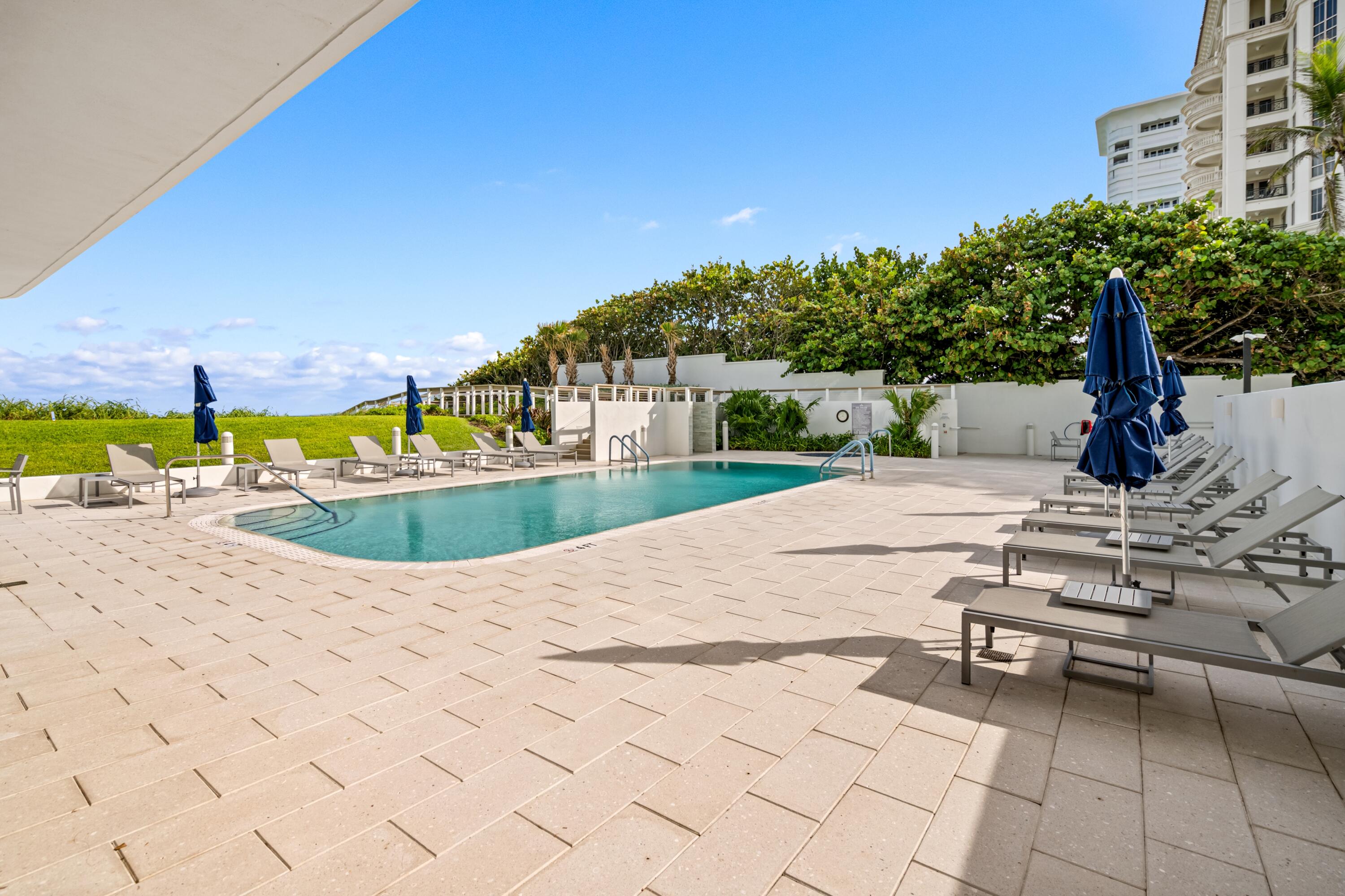 350 South Ocean Boulevard, Unit 12C Boca Raton, FL 33432 - Photo 39 of 50 a view of a swimming pool and lounge chairs