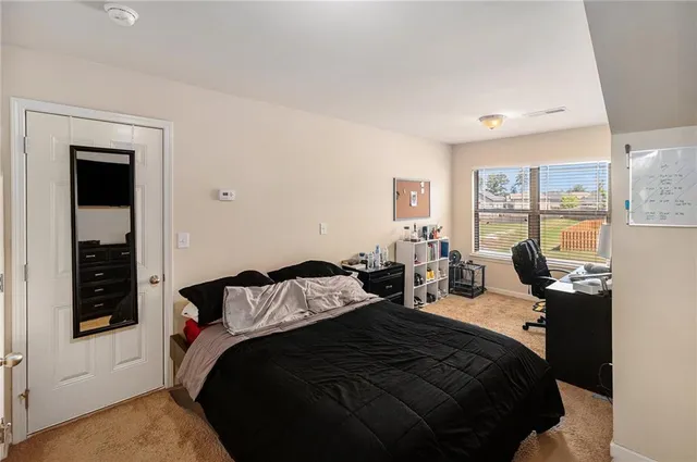 a bedroom with a bed a dresser next to a window