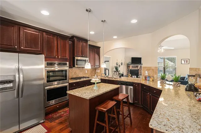 a kitchen with stainless steel appliances granite countertop a sink stove and refrigerator