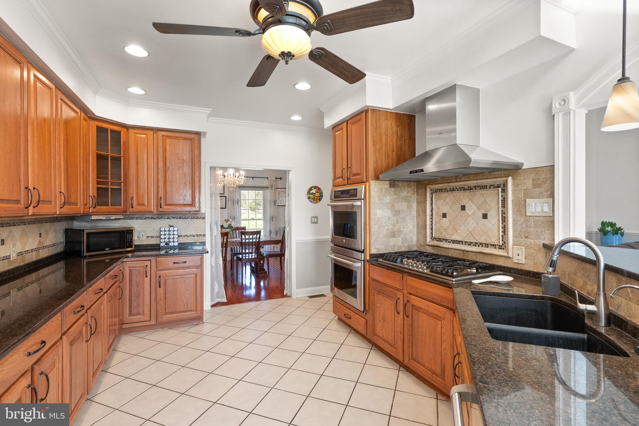 13145 Carriage Ford Road Nokesville, VA 20181 - Photo 11 of 70 a kitchen with stainless steel appliances granite countertop a stove sink and cabinets