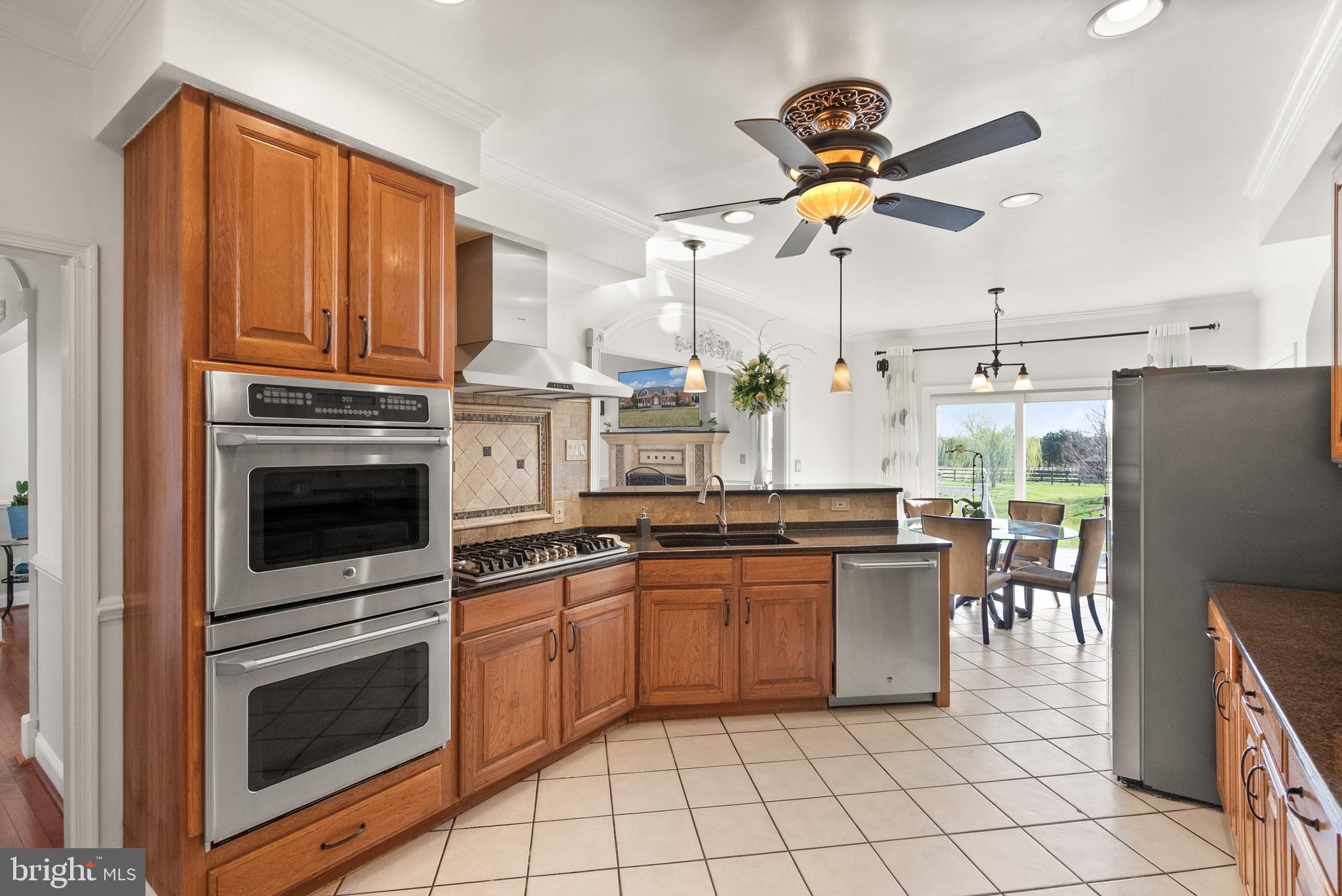 13145 Carriage Ford Road Nokesville, VA 20181 - Photo 12 of 70 a kitchen with granite countertop a sink stainless steel appliances and cabinets