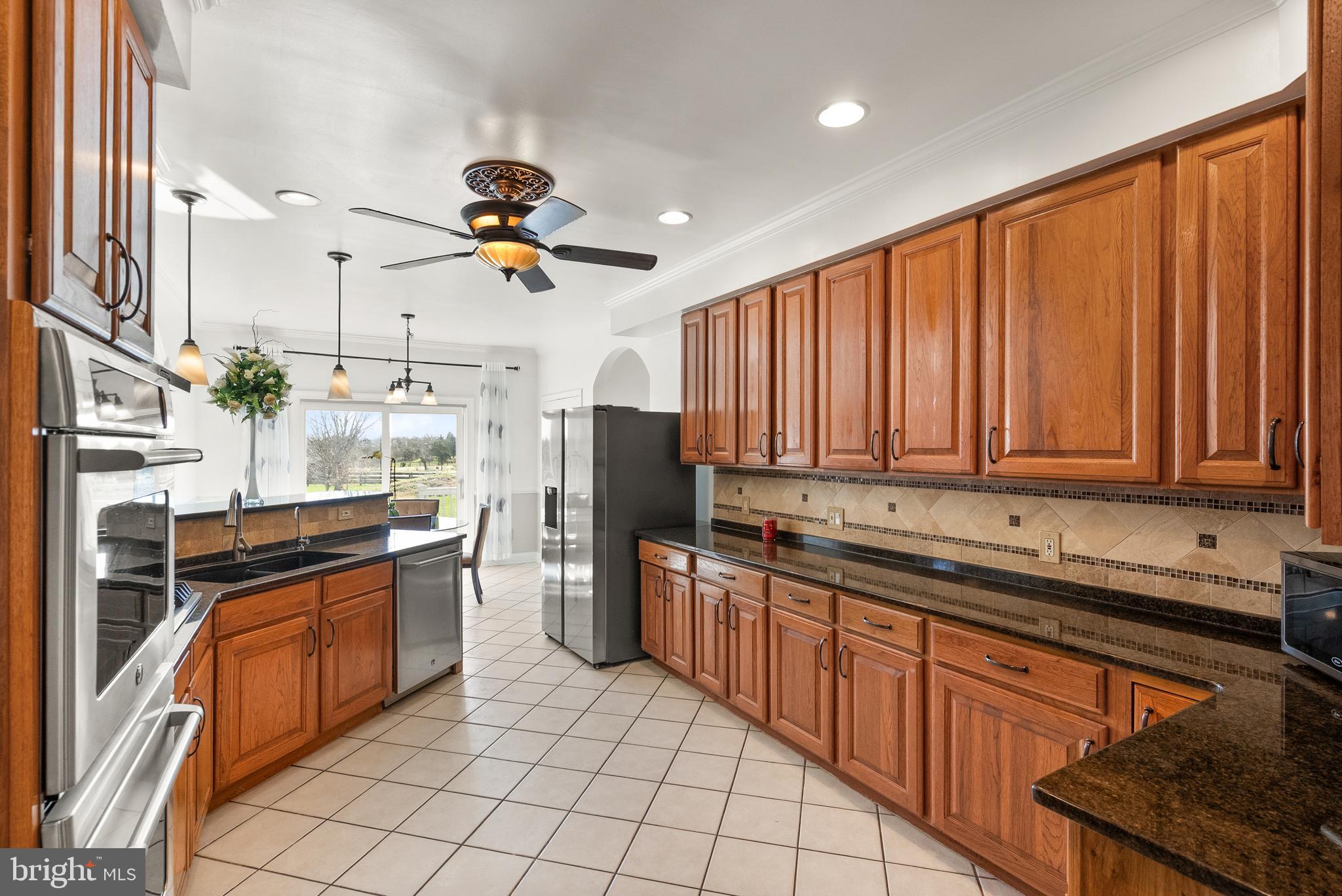 13145 Carriage Ford Road Nokesville, VA 20181 - Photo 13 of 70 a kitchen with stainless steel appliances granite countertop a stove a sink dishwasher and a refrigerator