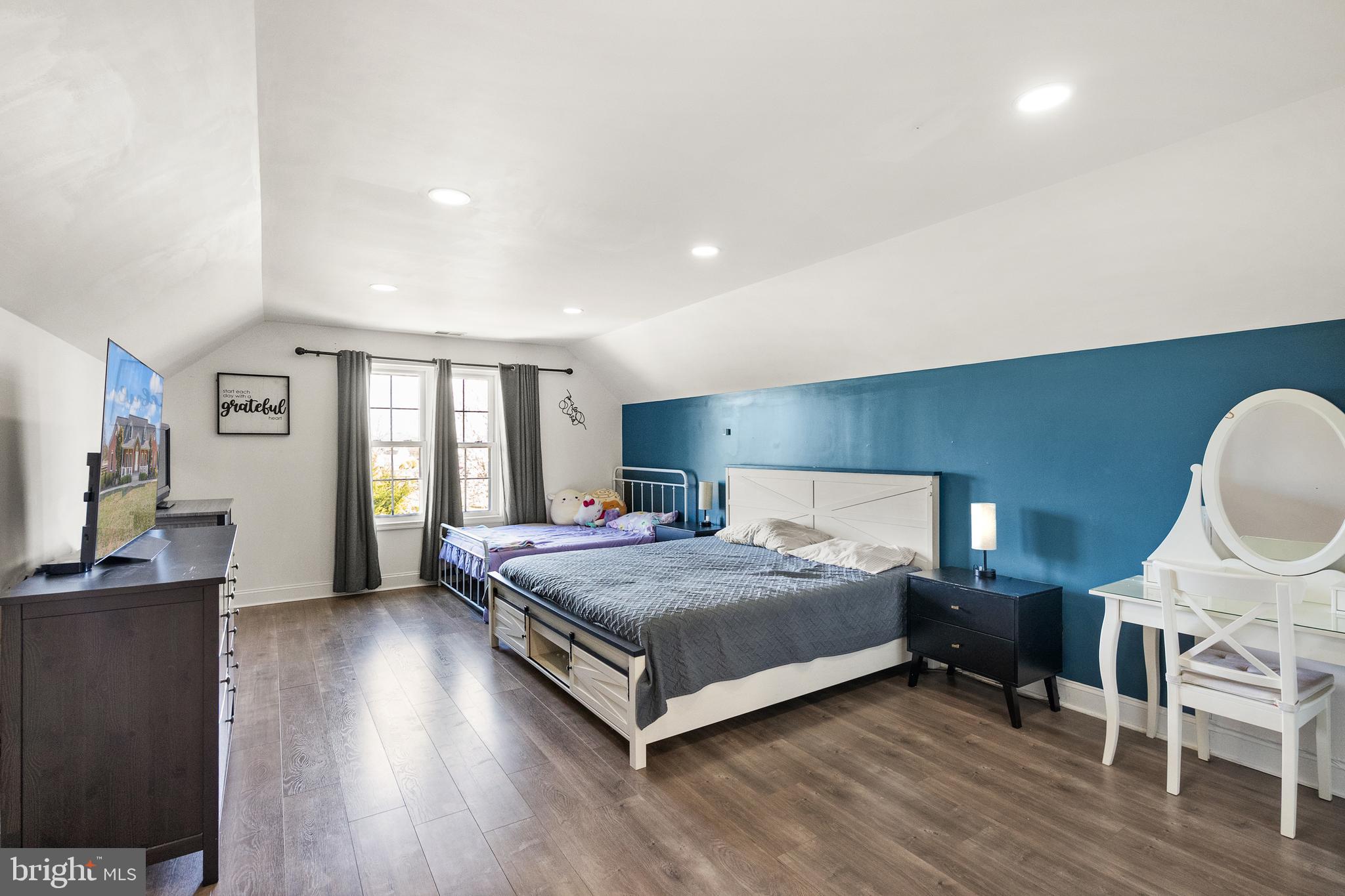 13145 Carriage Ford Road Nokesville, VA 20181 - Photo 38 of 70 a spacious bedroom with a bed a table and wooden floor