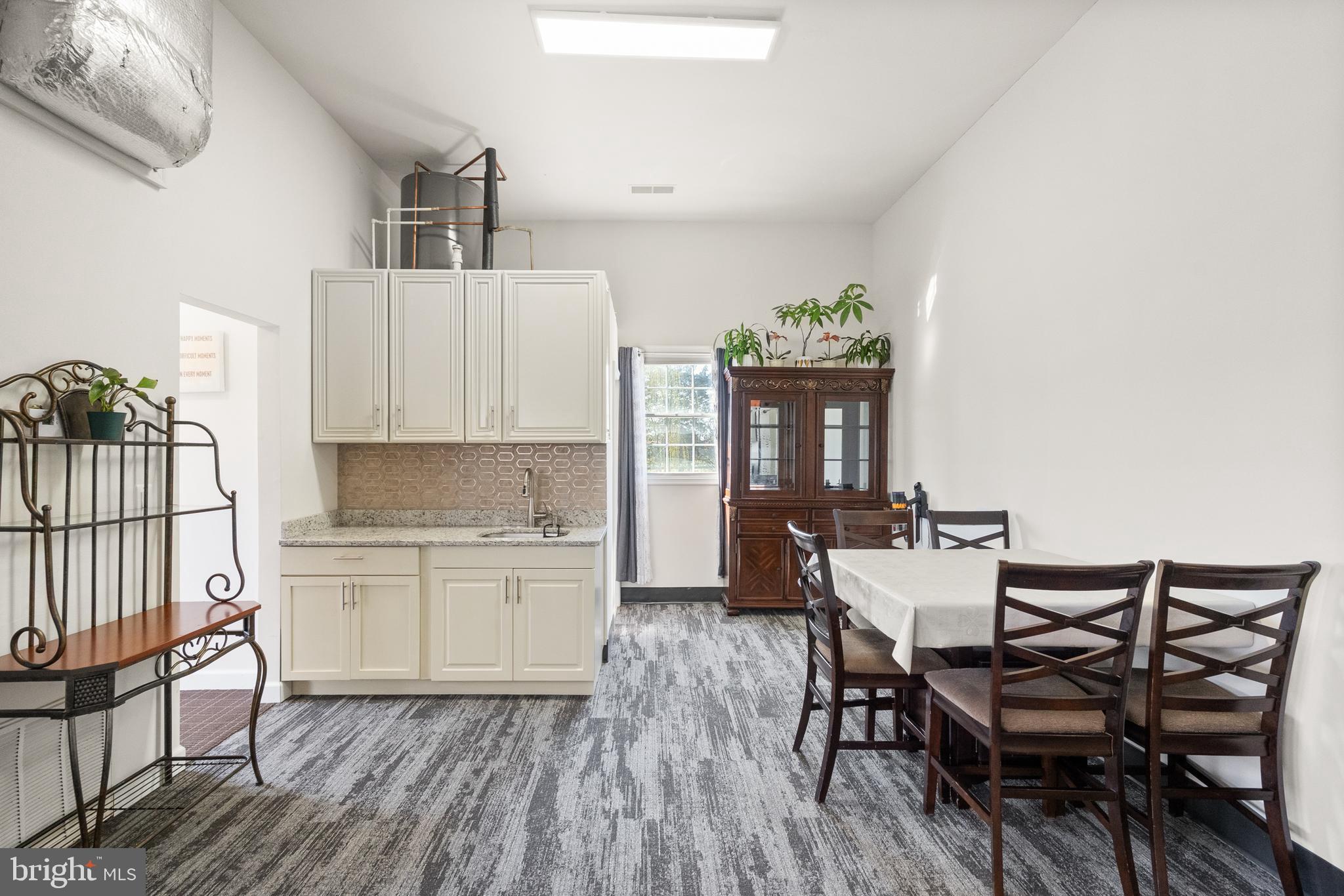 13145 Carriage Ford Road Nokesville, VA 20181 - Photo 64 of 70 a kitchen with a table chairs a sink dishwasher and cabinets with wooden floor