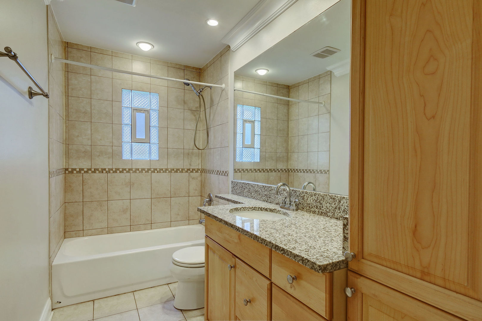 273 Raupp Boulevard Buffalo Grove, IL 60089 - Photo 7 of 18 a bathroom with a granite countertop sink a toilet a mirror and bathtub