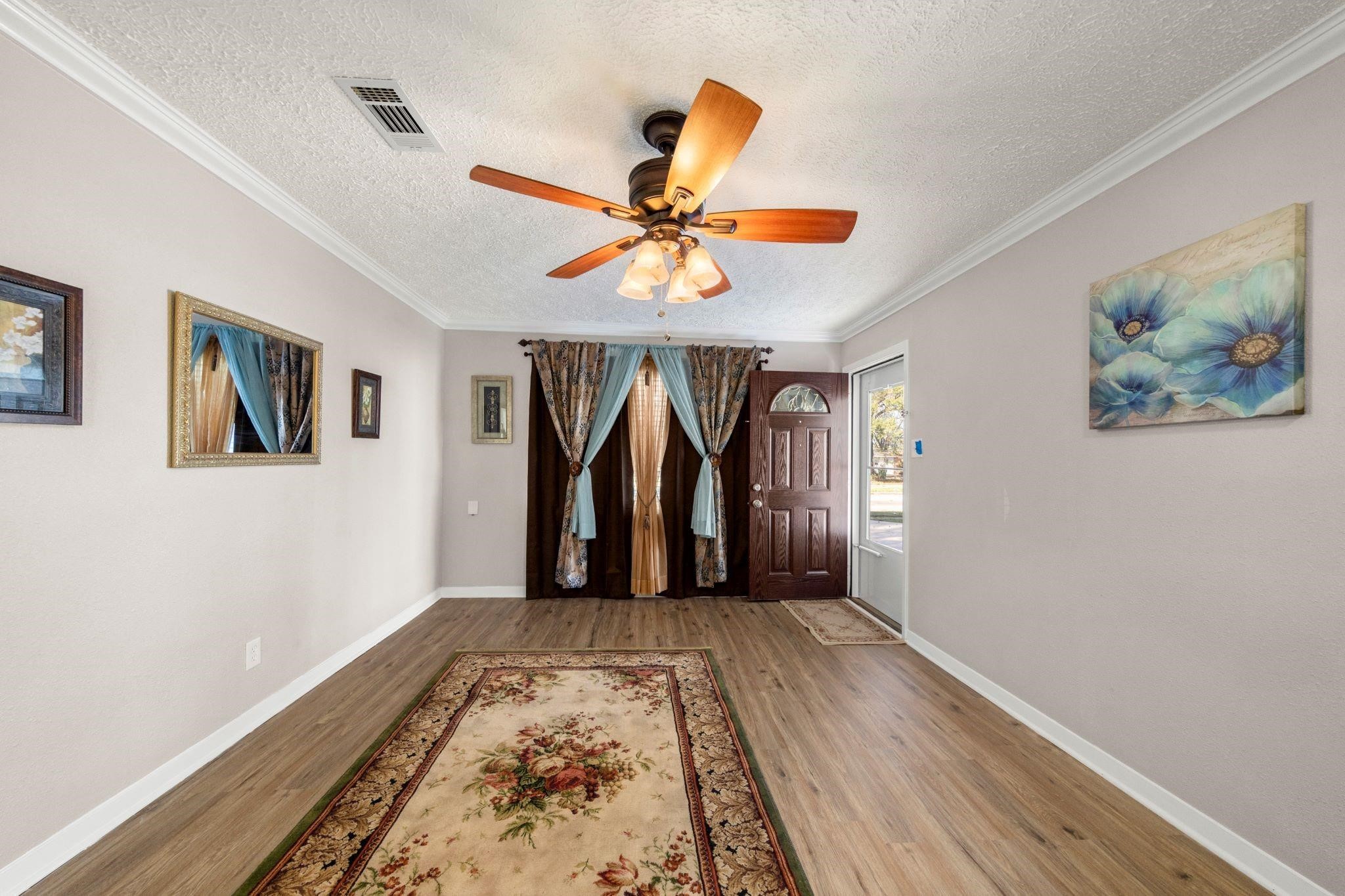 10128 Homestead Road Houston, TX 77016 - Photo 2 of 9 a view of a livingroom with wooden floor and a ceiling fan