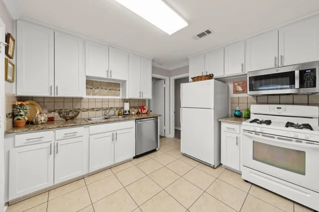 a kitchen with granite countertop cabinets and white appliances