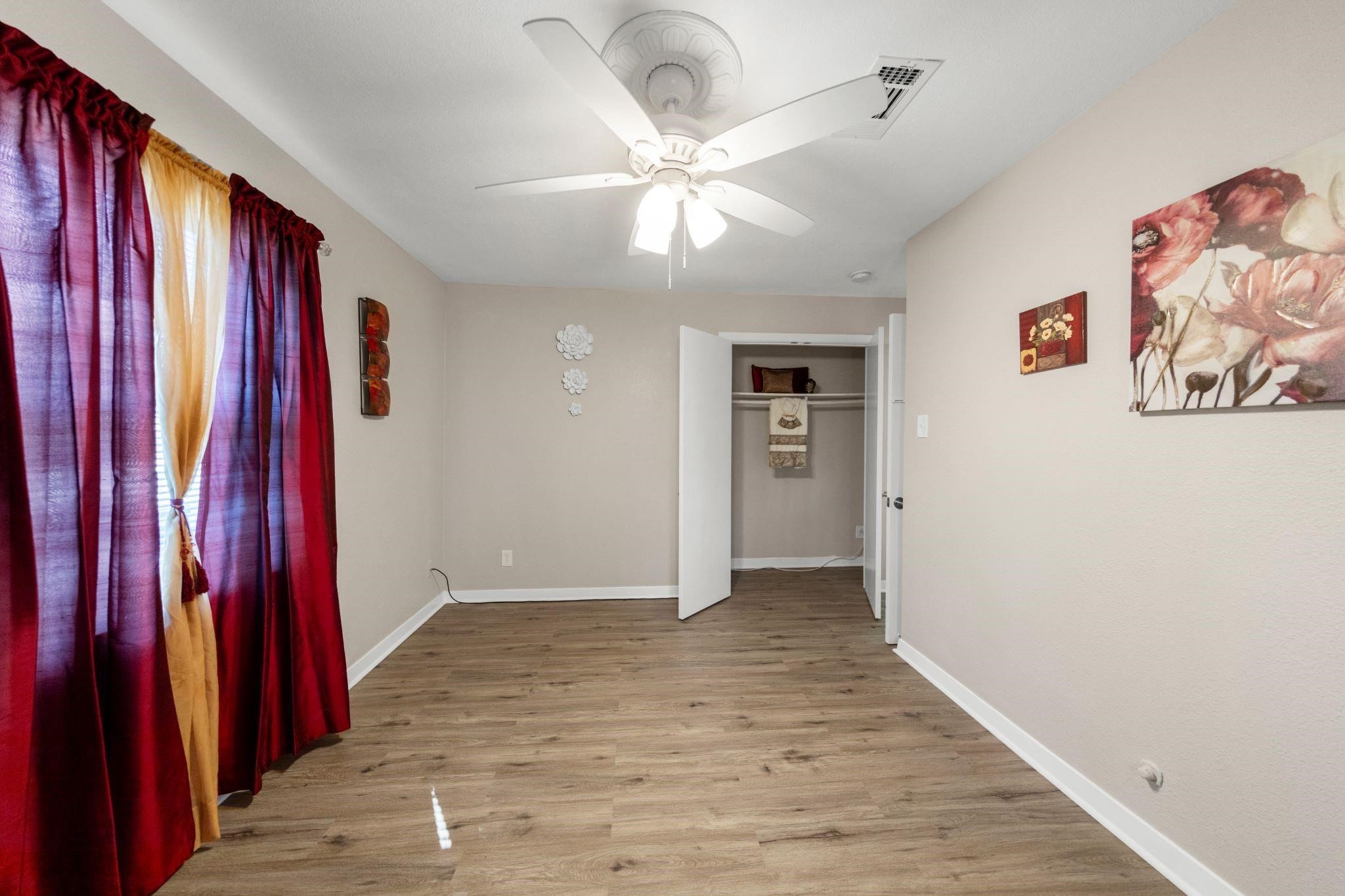10128 Homestead Road Houston, TX 77016 - Photo 4 of 9 a view of a bedroom with wooden floor and ceiling fan