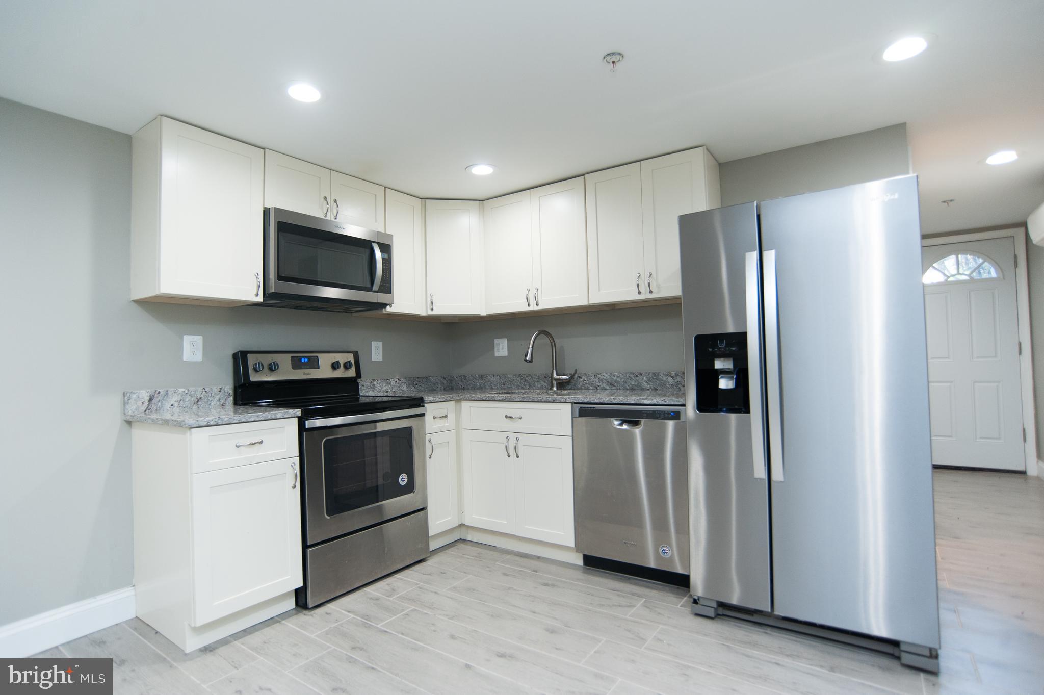 2022 4th Street Northeast, Unit B Washington, DC 20002 - Photo 4 of 16 a kitchen with stainless steel appliances granite countertop a refrigerator stove a sink and microwave