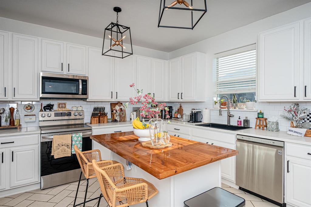 14521 Crystal Lake Drive Little Elm, TX 75068 - Photo 16 of 40 a kitchen with a appliances a center island and cabinets