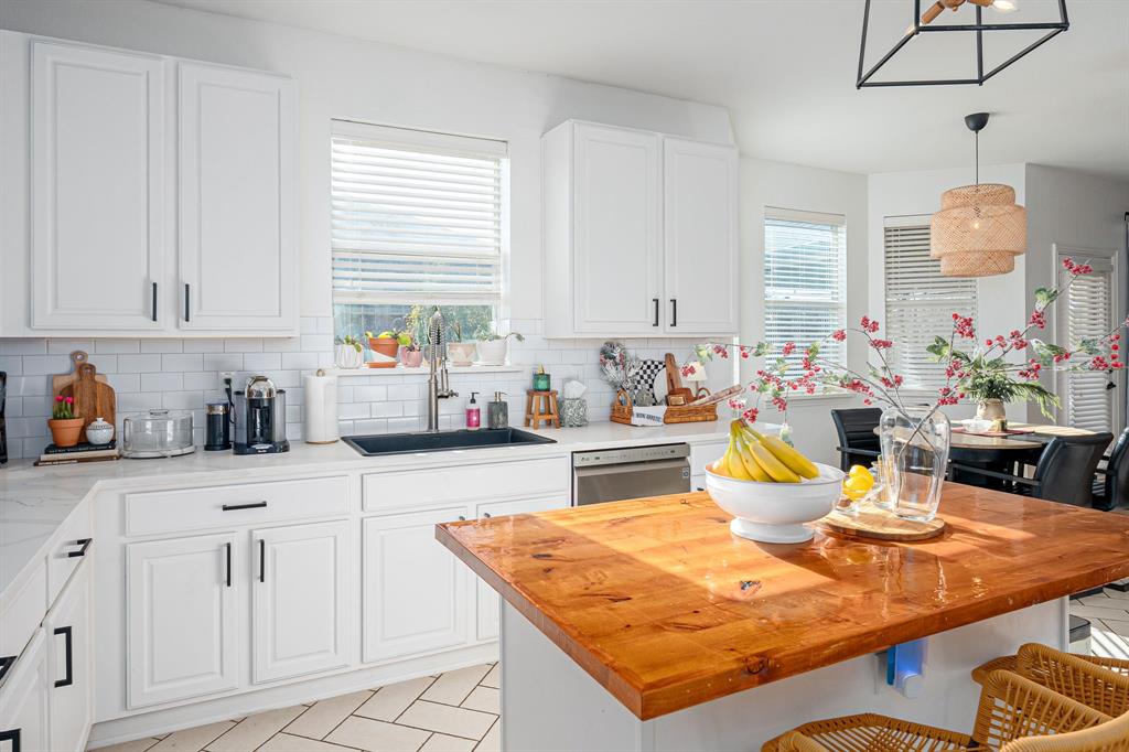 14521 Crystal Lake Drive Little Elm, TX 75068 - Photo 18 of 40 a kitchen with stainless steel appliances kitchen island granite countertop a table chairs and a white cabinets