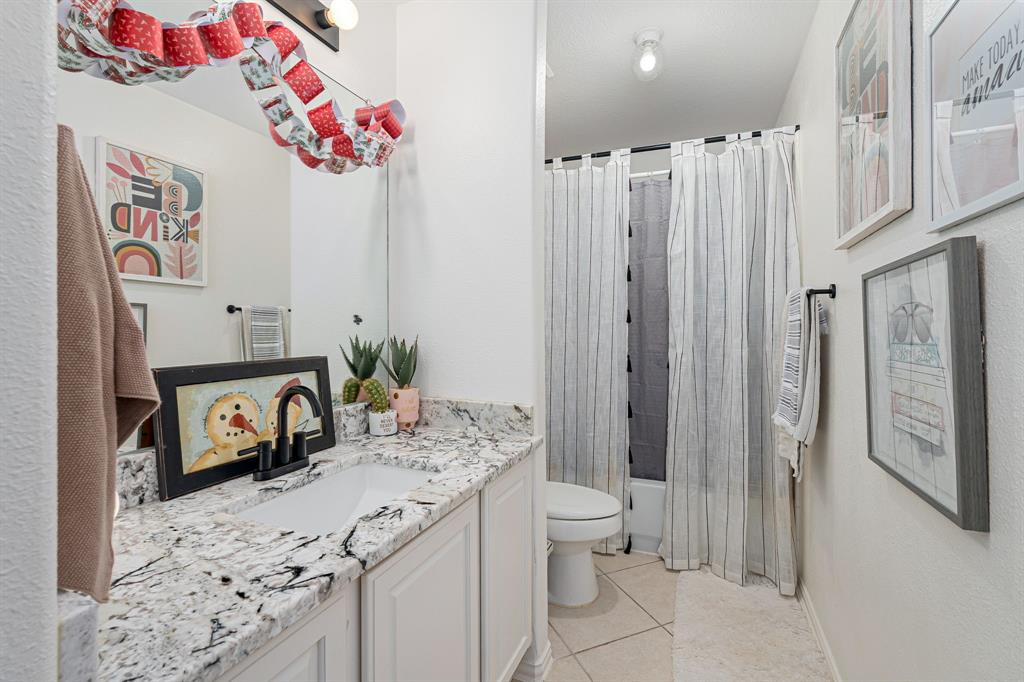 14521 Crystal Lake Drive Little Elm, TX 75068 - Photo 26 of 40 a bathroom with a granite countertop sink a toilet and a shower