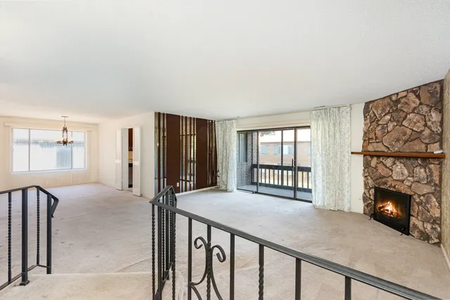 a view of an empty room with a fireplace and a window