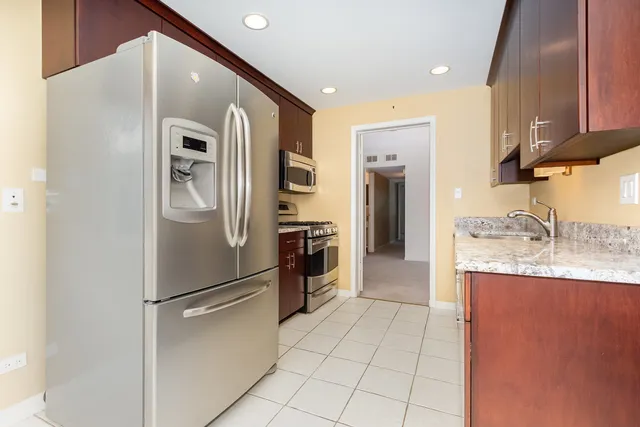 a kitchen with stainless steel appliances granite countertop a refrigerator and a sink