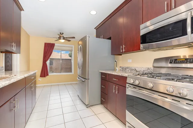 a kitchen with stainless steel appliances granite countertop a stove a sink and a microwave