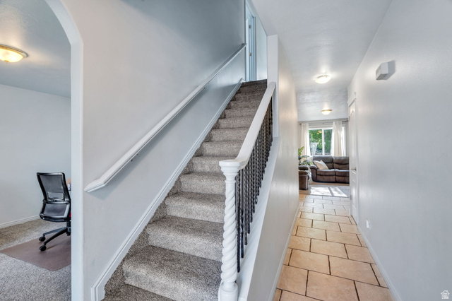1727 South Sandhill Road Orem, UT 84058 - Photo 3 of 27 Carpeted staircase with white newel posts and black metal balusters