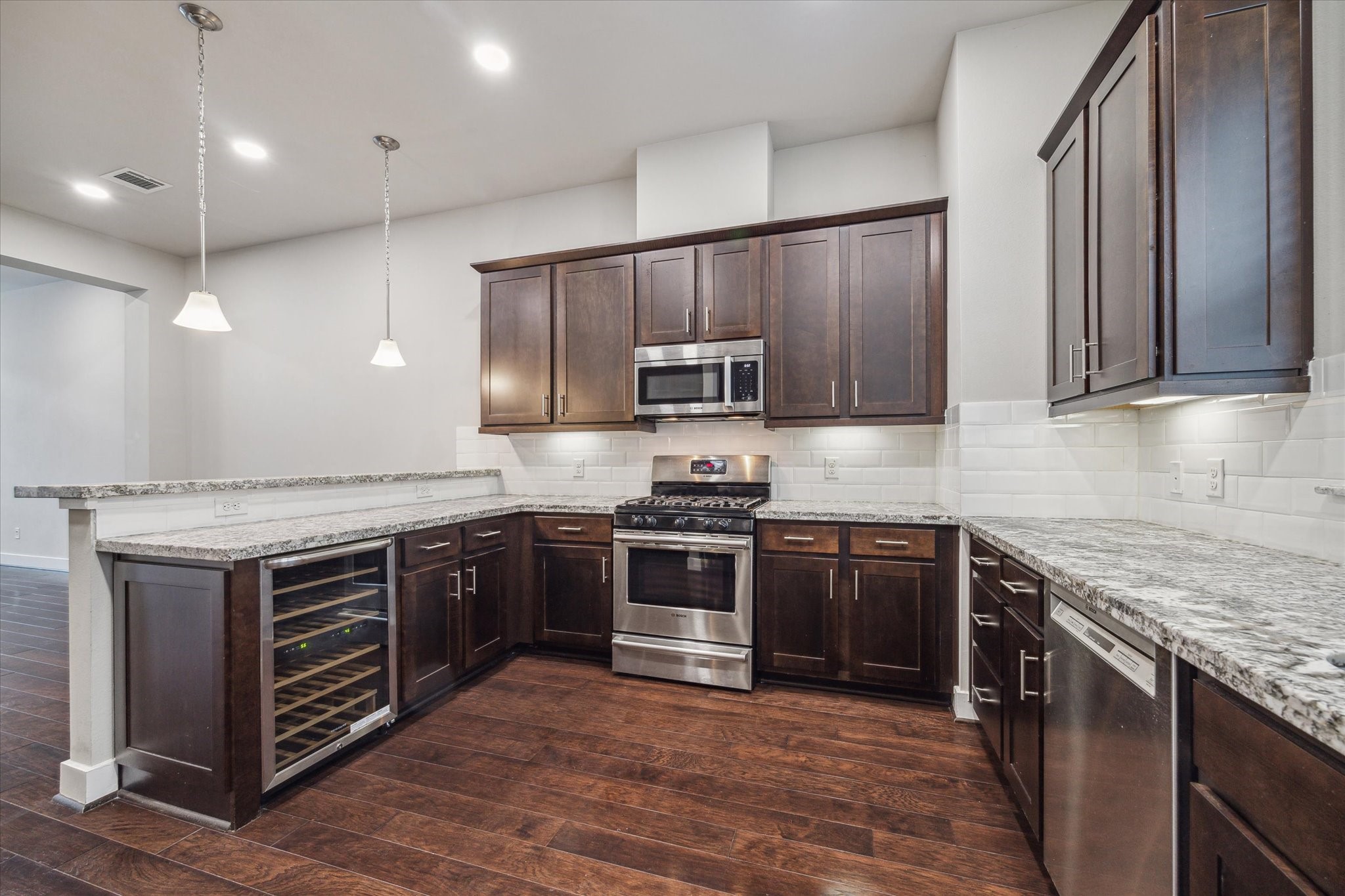 4508 Cornish Street, Unit A Houston, TX 77007 - Photo 4 of 22 Stainless steel appliances include a wine refrigerator, gas range, microwave, and dishwasher.