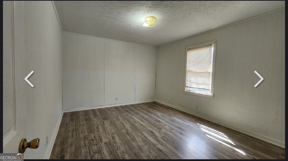 135 Alabama Street Griffin, GA 30223 - Photo 4 of 5 wooden floor in an empty room with a window
