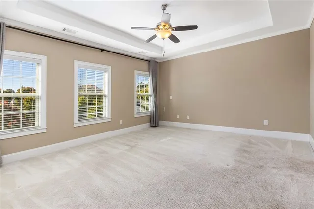 an empty room with closet and a ceiling fan