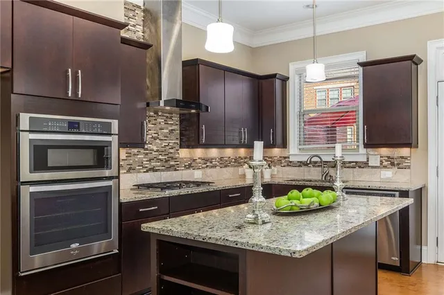 a kitchen with stainless steel appliances kitchen island granite countertop a sink and a stove
