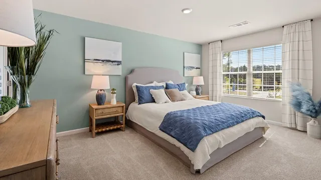 a spacious bedroom with a bed table chair and a window