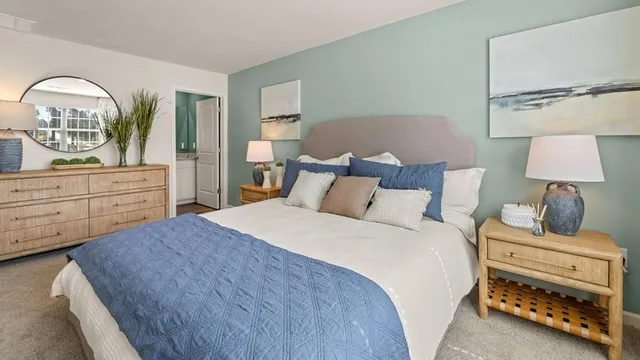 a bedroom with a bed and a lamp on dresser