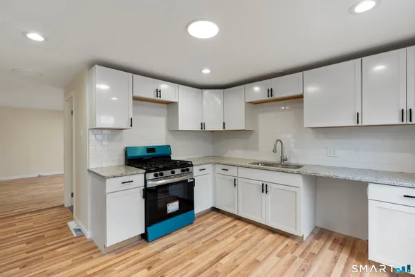 a kitchen with stainless steel appliances granite countertop a stove and a sink