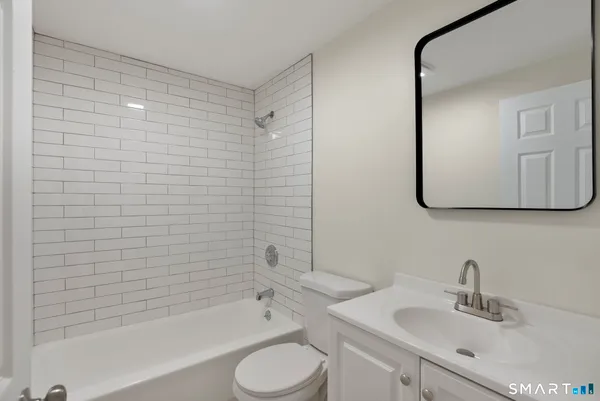 a bathroom with a bathtub shower sink and a toilet