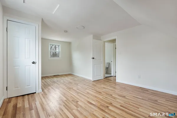 a view of an empty room with closet and a window