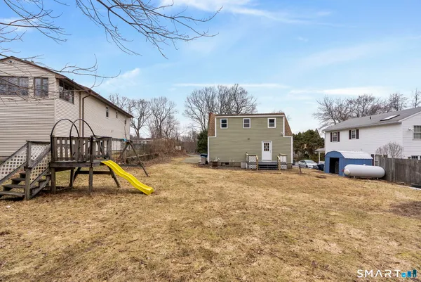 a view of a house with backyard and a slide