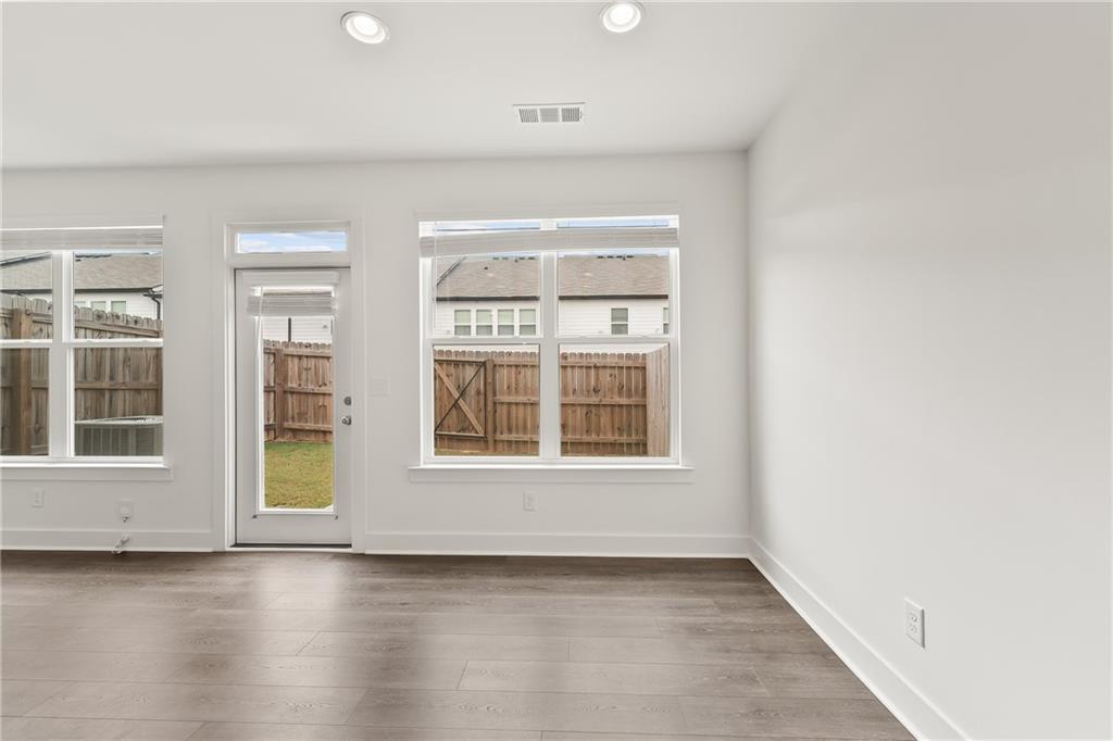 98 Auburn Valley Way Auburn, GA 30011 - Photo 14 of 47 an empty room with wooden floor and windows