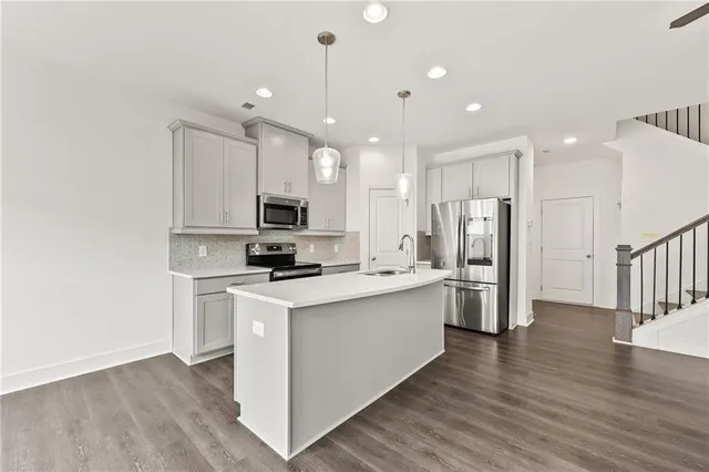 a kitchen with stainless steel appliances a refrigerator sink and microwave
