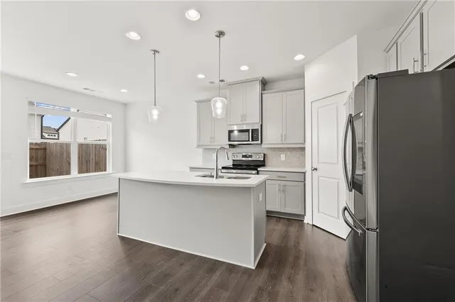 a kitchen with stainless steel appliances granite countertop a refrigerator a sink and a stove