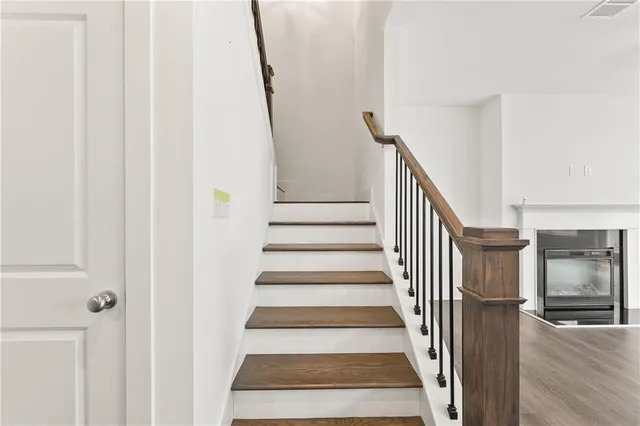 a view of staircase with lots of frames on wall and wooden floor