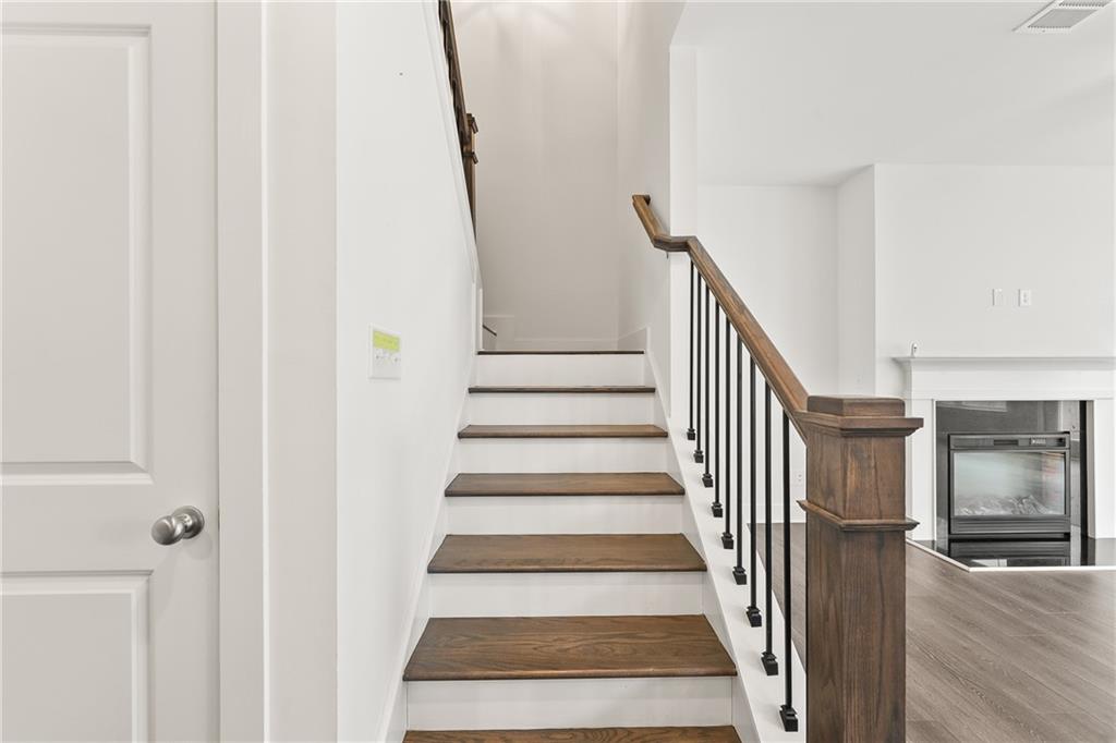 98 Auburn Valley Way Auburn, GA 30011 - Photo 19 of 47 a view of staircase with lots of frames on wall and wooden floor