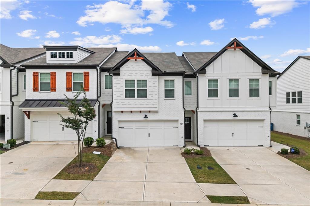 98 Auburn Valley Way Auburn, GA 30011 - Photo 2 of 47 a view of a white house with large windows and a small yard
