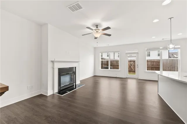 an empty room with windows and fireplace