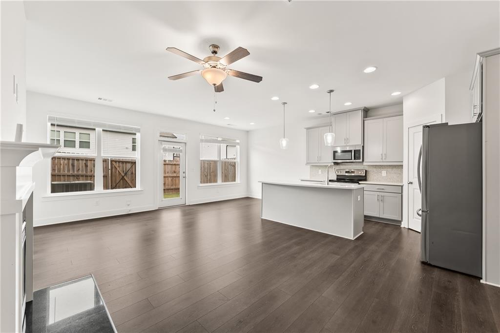 98 Auburn Valley Way Auburn, GA 30011 - Photo 9 of 47 a view of kitchen with refrigerator microwave and stove with wooden floor