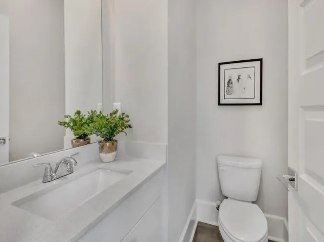 a bathroom with a toilet a sink and mirror