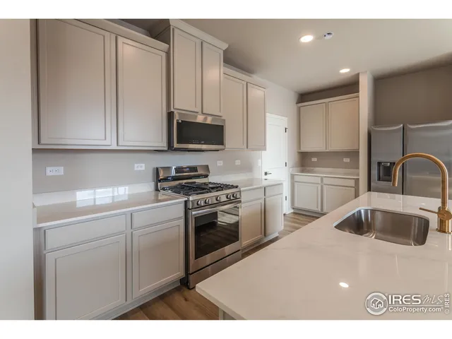a kitchen with kitchen island a sink stainless steel appliances and cabinets