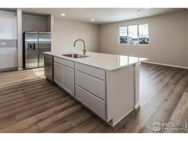a kitchen with a sink cabinets and wooden floor