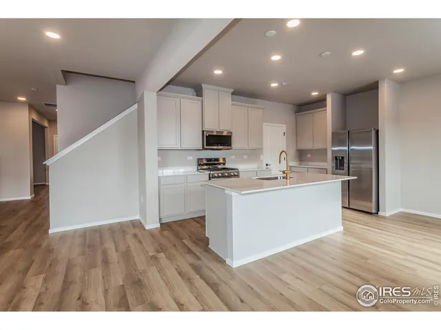 a kitchen with a refrigerator and a stove top oven