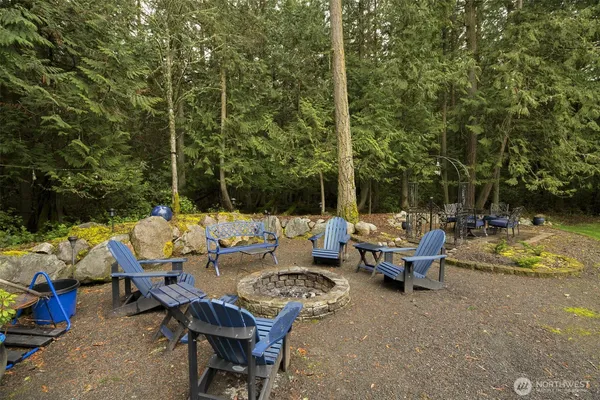 a view of a patio with table and chairs potted plants and large trees
