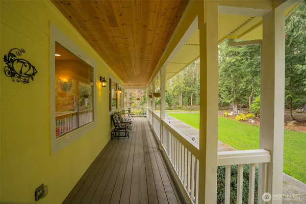 a view of a patio with table and chairs potted plants and floor to ceiling window