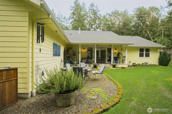 a view of a house with a yard plants and large tree