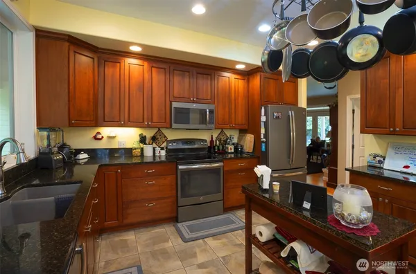 a kitchen with a appliances dining table and chairs