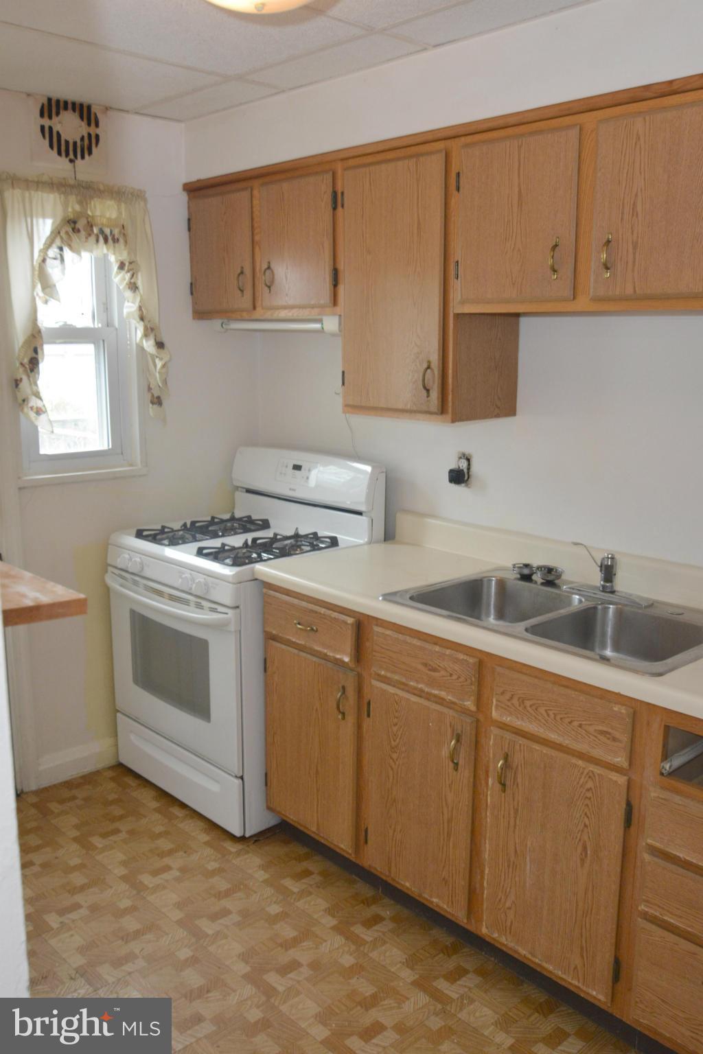 1929 Haselmere Road Baltimore, MD 21222 - Photo 8 of 22 a kitchen with cabinets appliances a sink and a window