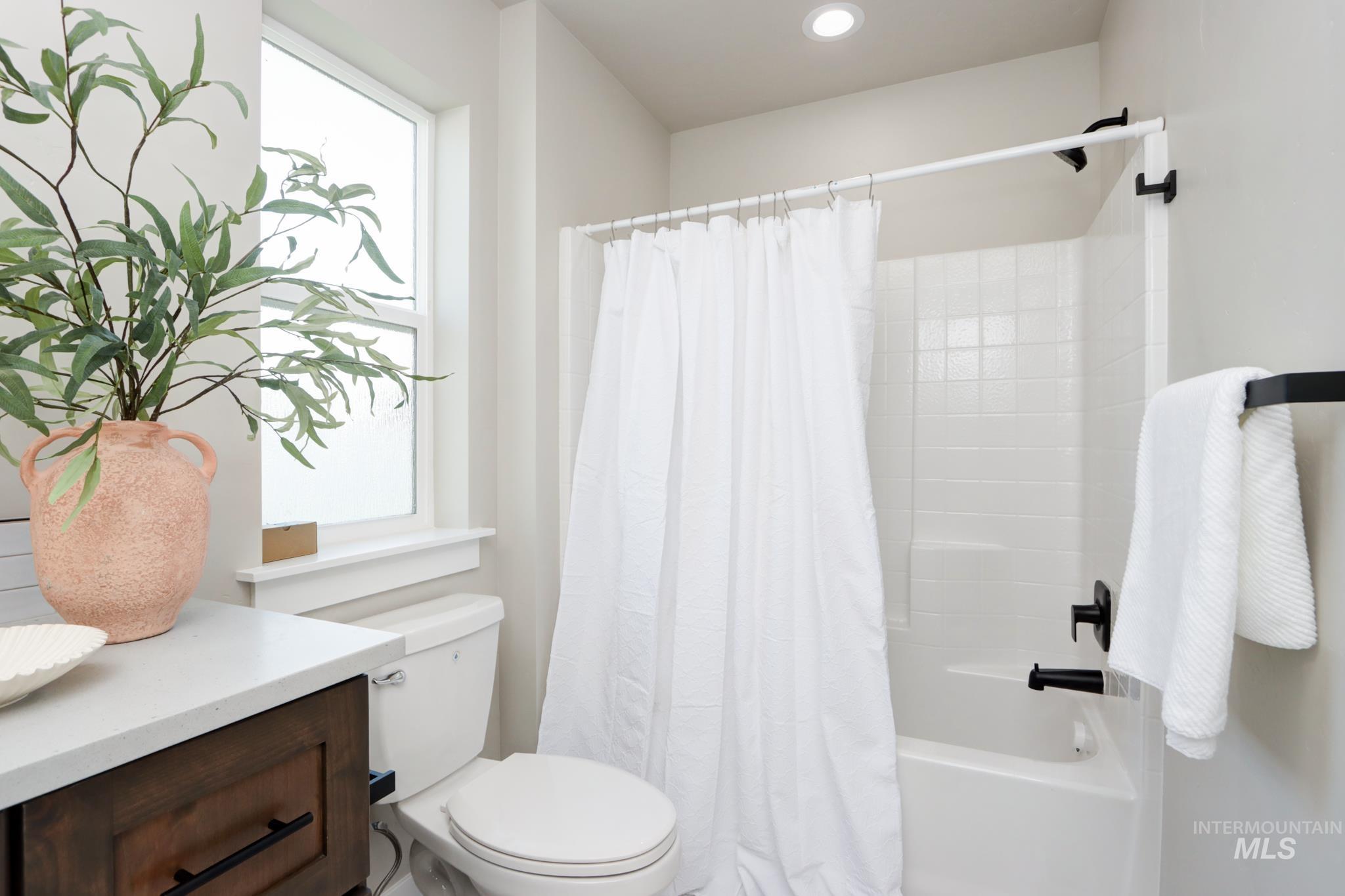 848 North 5th Street Nyssa, OR 97913 - Photo 16 of 49 Bathroom featuring a bathtub with subway tile surround, matte black fixtures, and a window