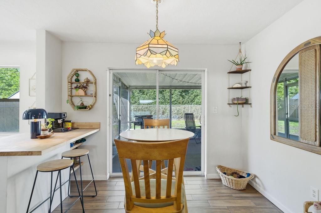 8520 109th Way North Seminole, FL 33772 - Photo 13 of 40 a dining room with furniture a chandelier and wooden floor